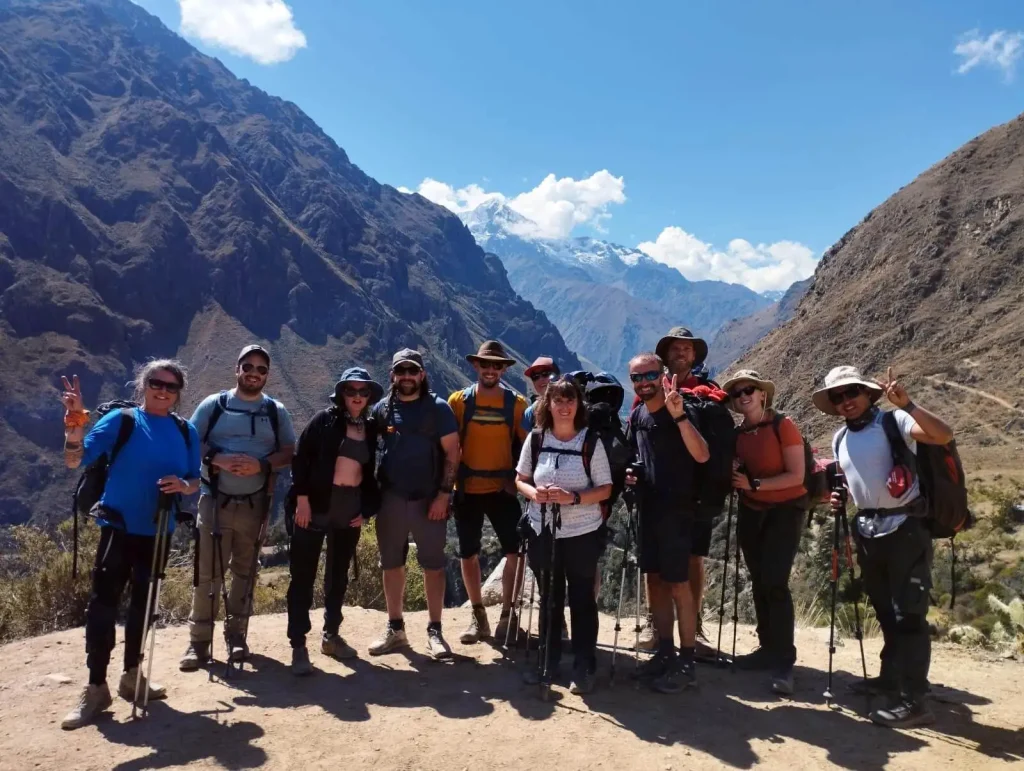 Grupo de excursionistas en el Camino Inca, rodeados de imponentes montañas andinas.