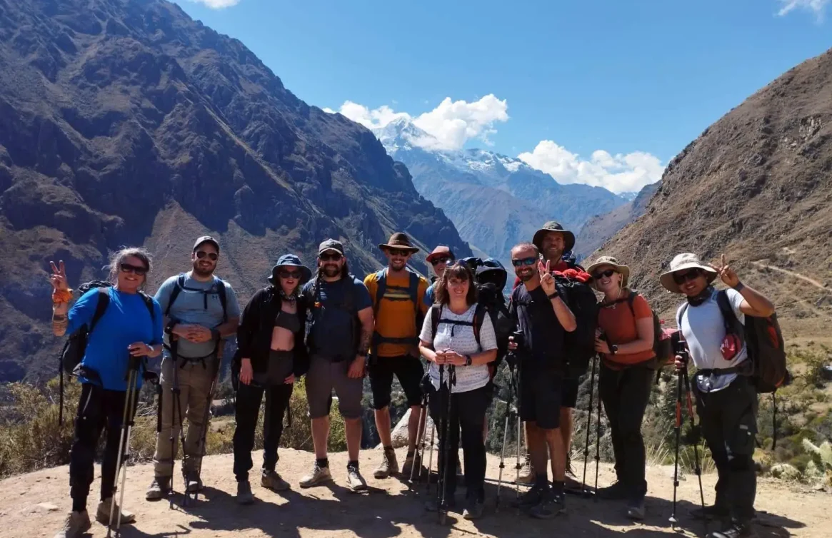 Grupo de excursionistas en el Camino Inca, rodeados de imponentes montañas andinas.