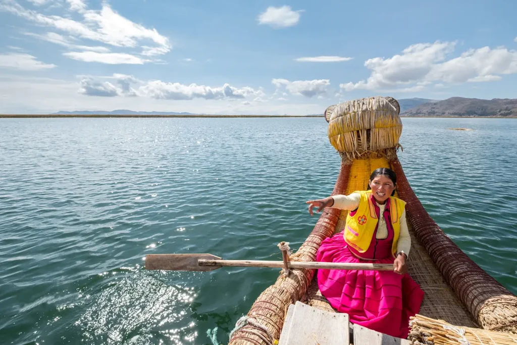Mujer remando en una barca de totora en el lago Titicaca.