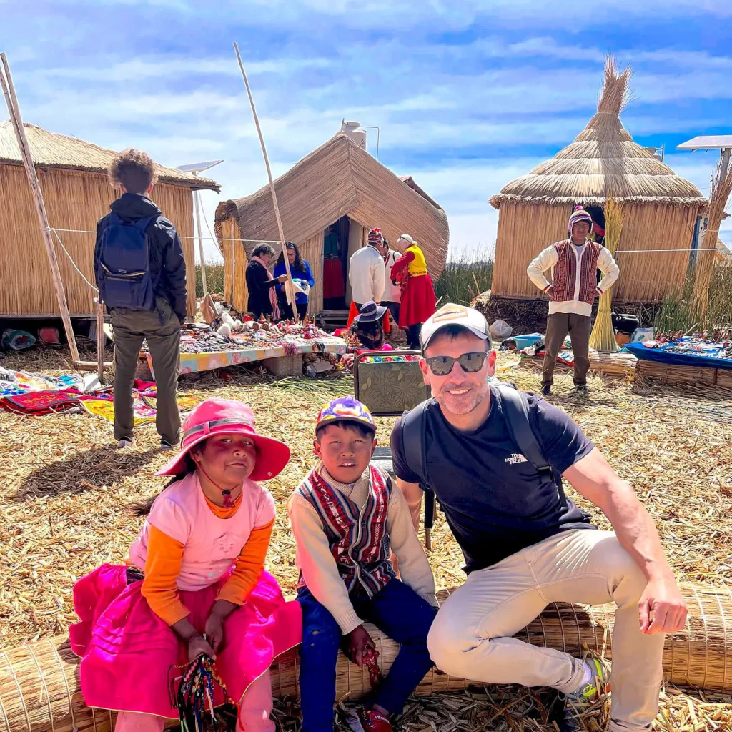 Turista con niños en una isla flotante del lago Titicaca.