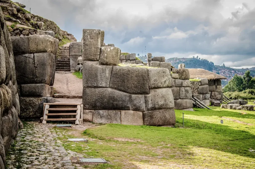Ruinas de Sacsayhuamán con grandes bloques de piedra y escaleras.