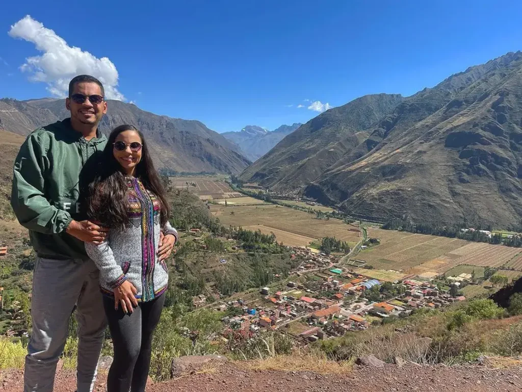Um casal de turistas apreciando a vista panorâmica do Vale Sagrado dos Incas.