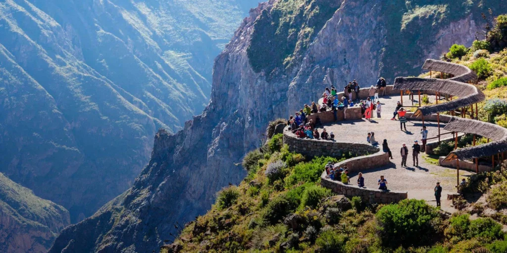 Mirador con turistas en el Cañón del Colca rodeado de montañas altas.