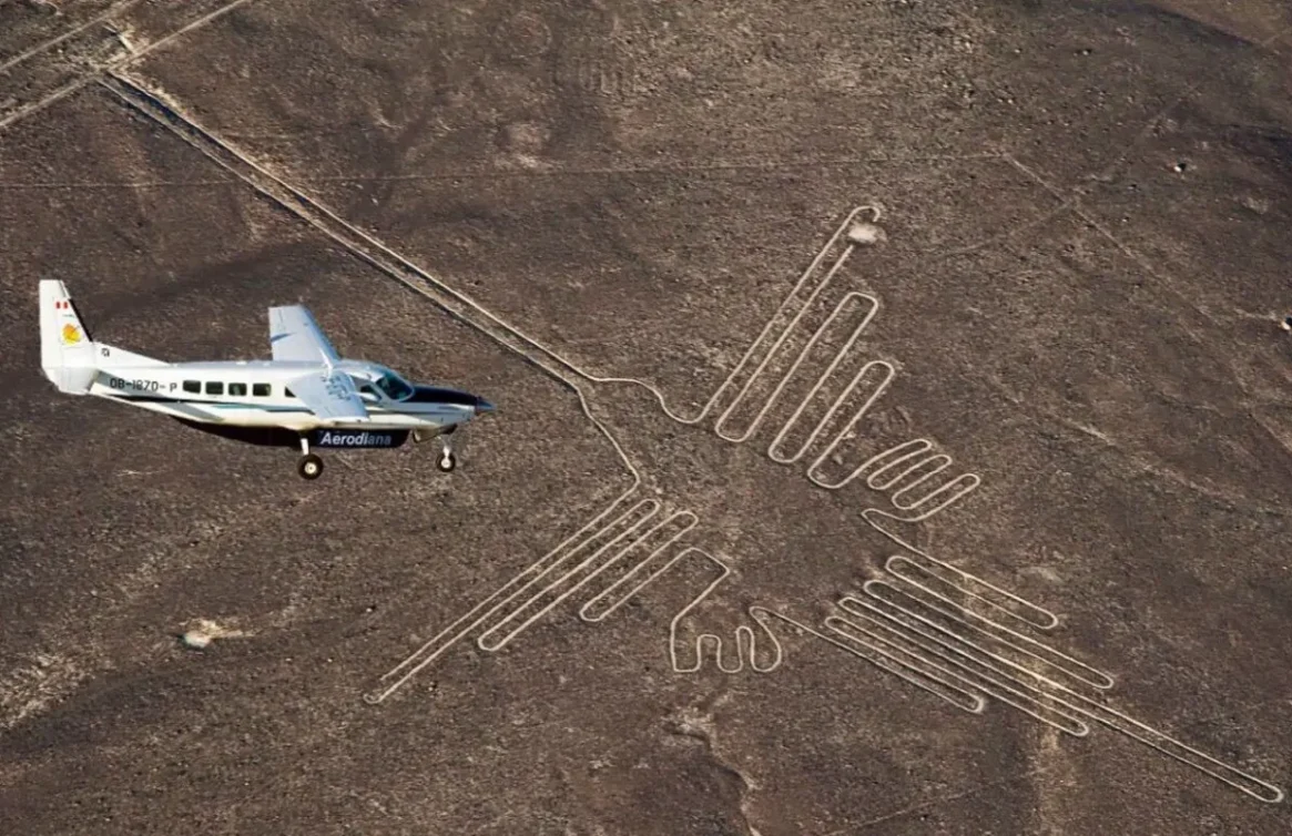 Avioneta "Aerodiana" vuela sobre la línea de Nazca con figura de colibrí en el desierto.