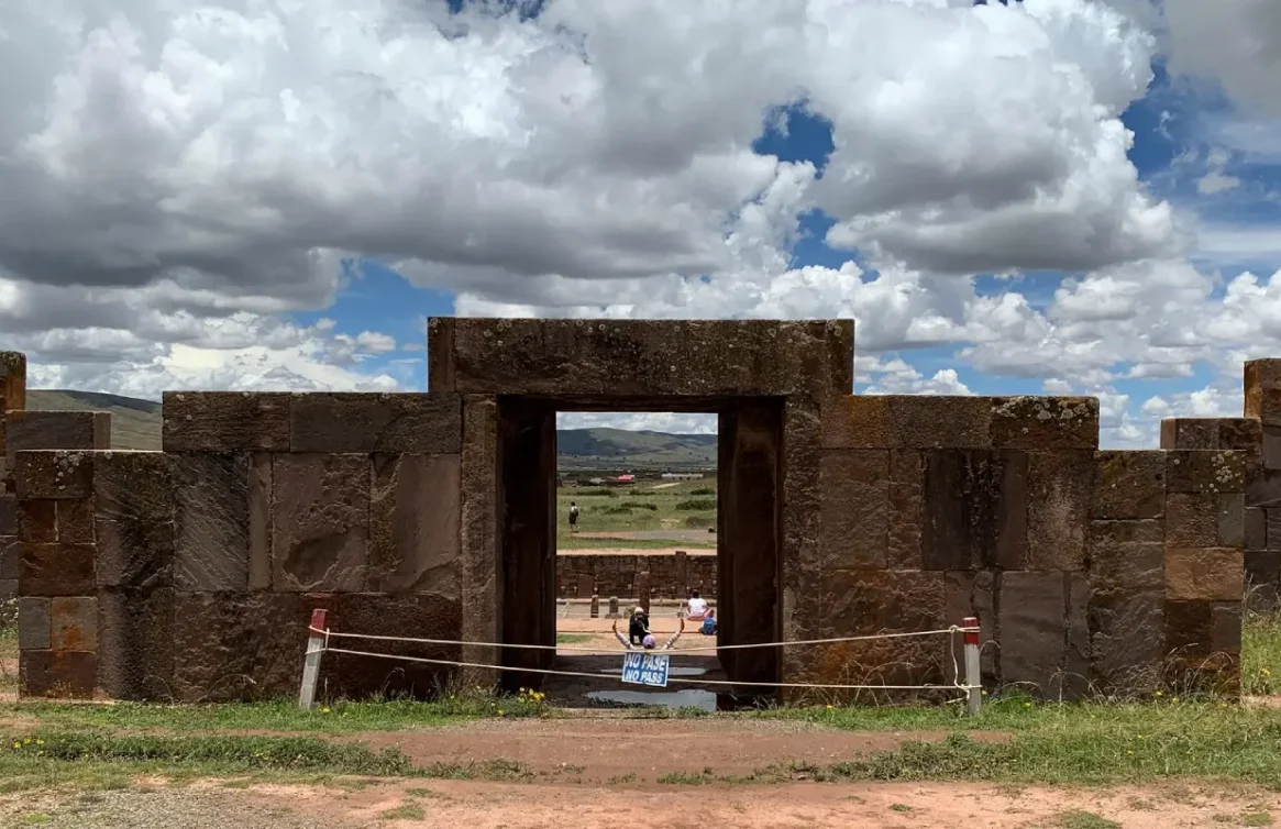 Porta de pedra em Tiwanaku, um sítio arqueológico sob um céu nublado na Bolívia.
