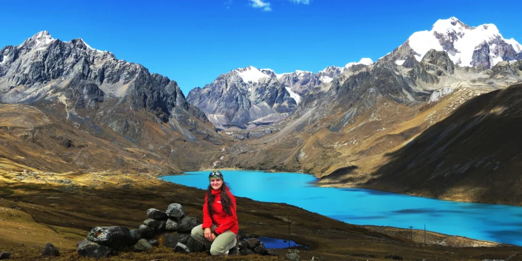 Turista en las 7 lagunas de Ausangate, rodeada de montañas nevadas.
