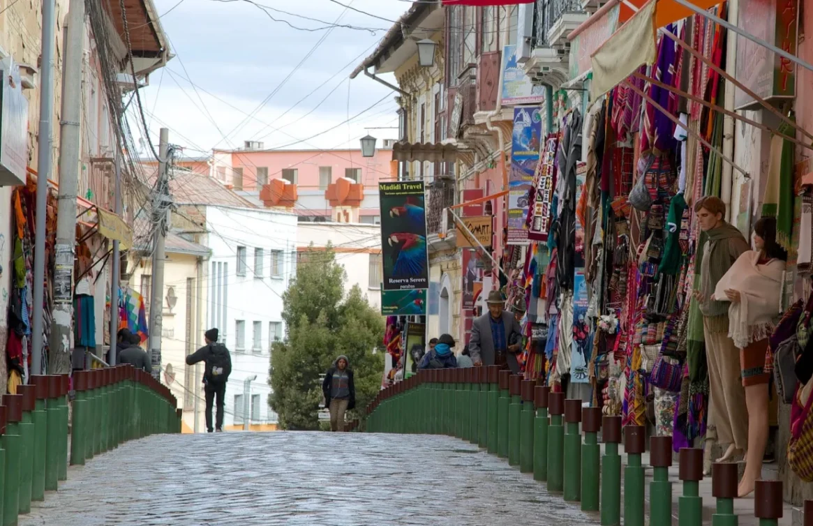 Rua de paralelepípedos em La Paz com lojas de artesanato em ambos os lados.