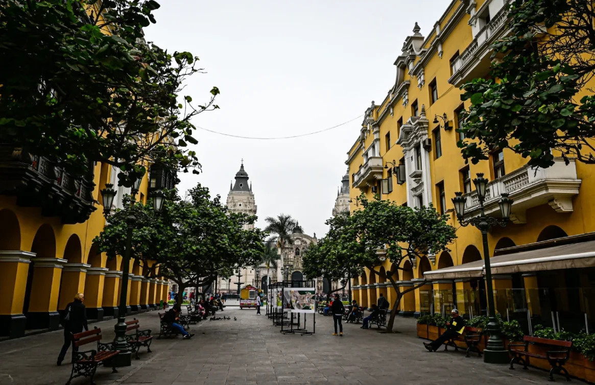 Calle peatonal con árboles y edificios amarillos en el centro de Lima