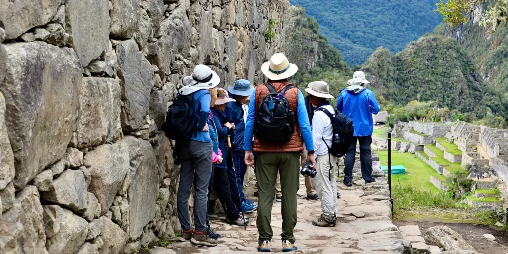 Grupo de turistas explorando las antiguas murallas y terrazas de Machu Picchu
