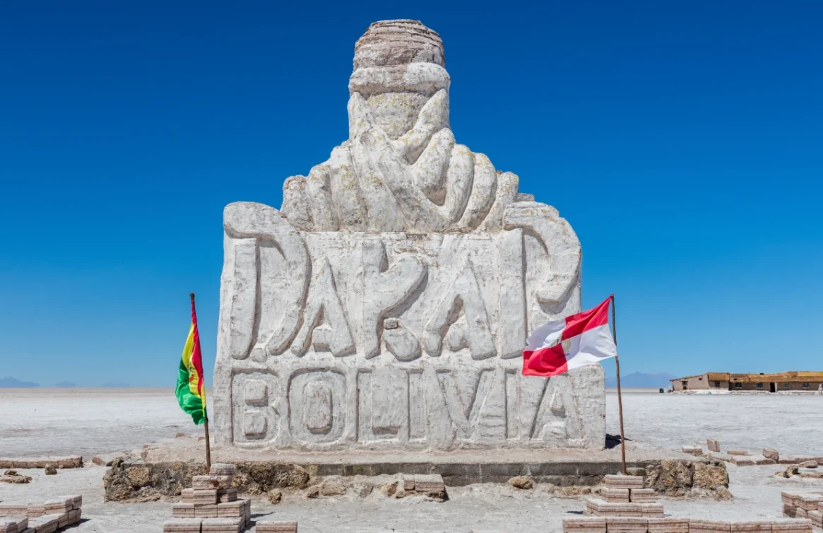 Monumento de Dakar no Salar de Uyuni com as bandeiras da Bolívia e do Peru.