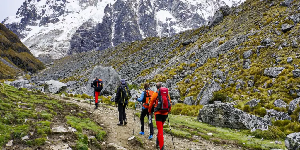 Grupo de excursionistas caminando hacia la montaña nevada Salkantay en Cusco.