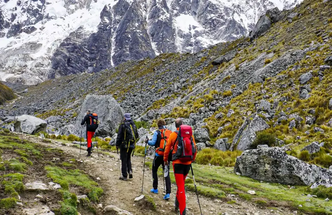 Grupo de excursionistas caminando hacia la montaña nevada Salkantay en Cusco.