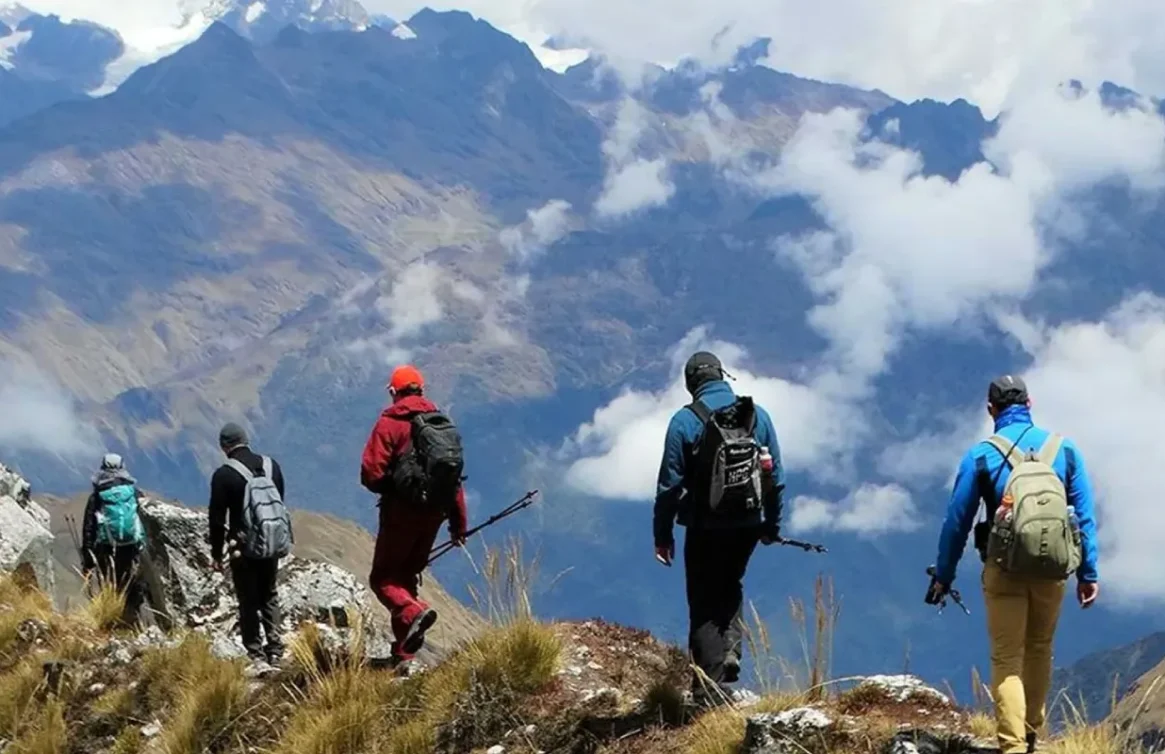 Caminhantes percorrendo a Trilha Salkantay cercada por montanhas cobertas de neve.