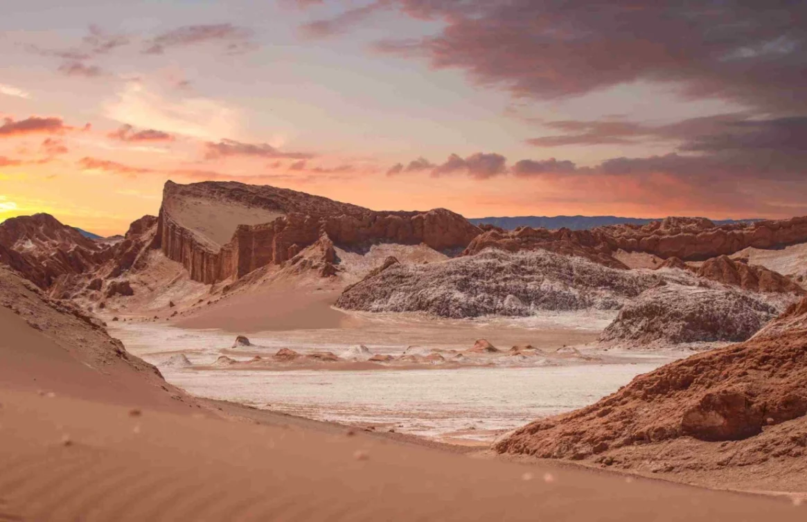 Paisagem desértica com formações rochosas e pôr do sol em San Pedro de Atacama.