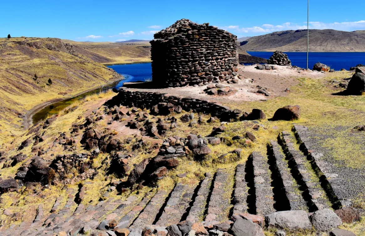 Antiga Chullpa em Sillustani cercada por colinas e lagoa.