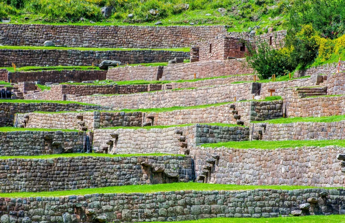 Terraços agrícolas incas de Tipón cercados por vegetação verde