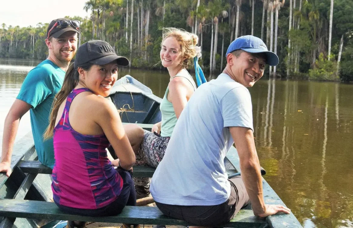 Turistas sorridentes passeando de barco no Lago Sandoval.